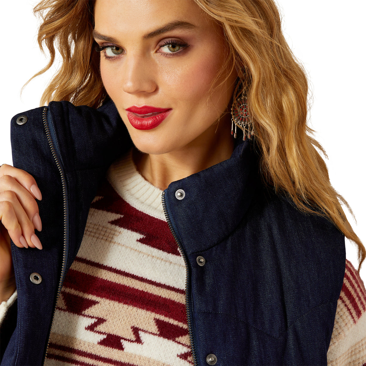 Woman wearing a navy vest over a patterned sweater on a white background