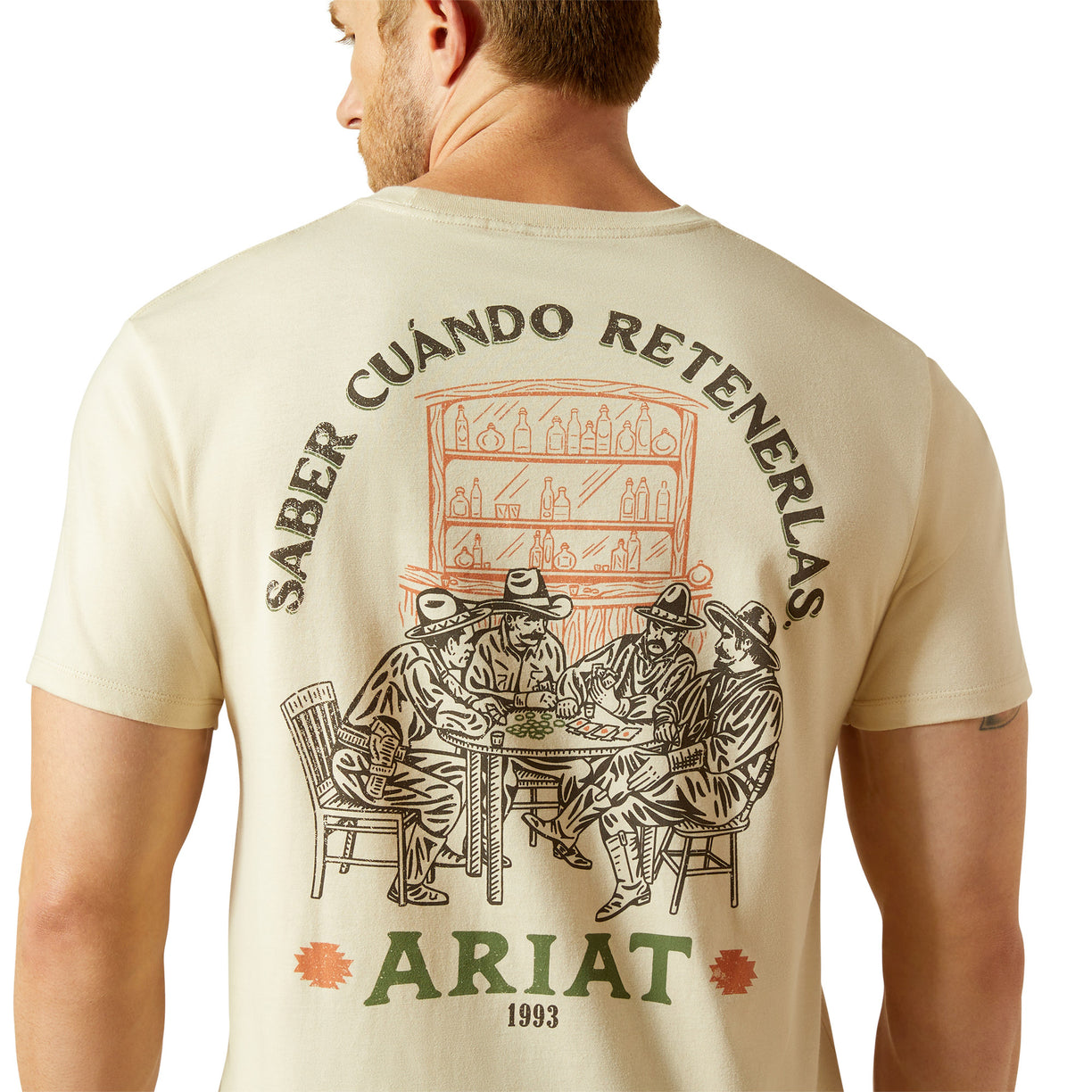 Beige t-shirt with graphic design and text on the back, featuring the brand 'Ariat'.