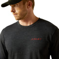 Man wearing a dark gray Ariat long-sleeve shirt on a white background