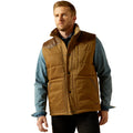 Man wearing a brown quilted vest over a blue shirt on a white background