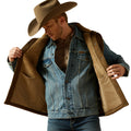 Man wearing a denim jacket with brown fur lining and a cowboy hat on a white background