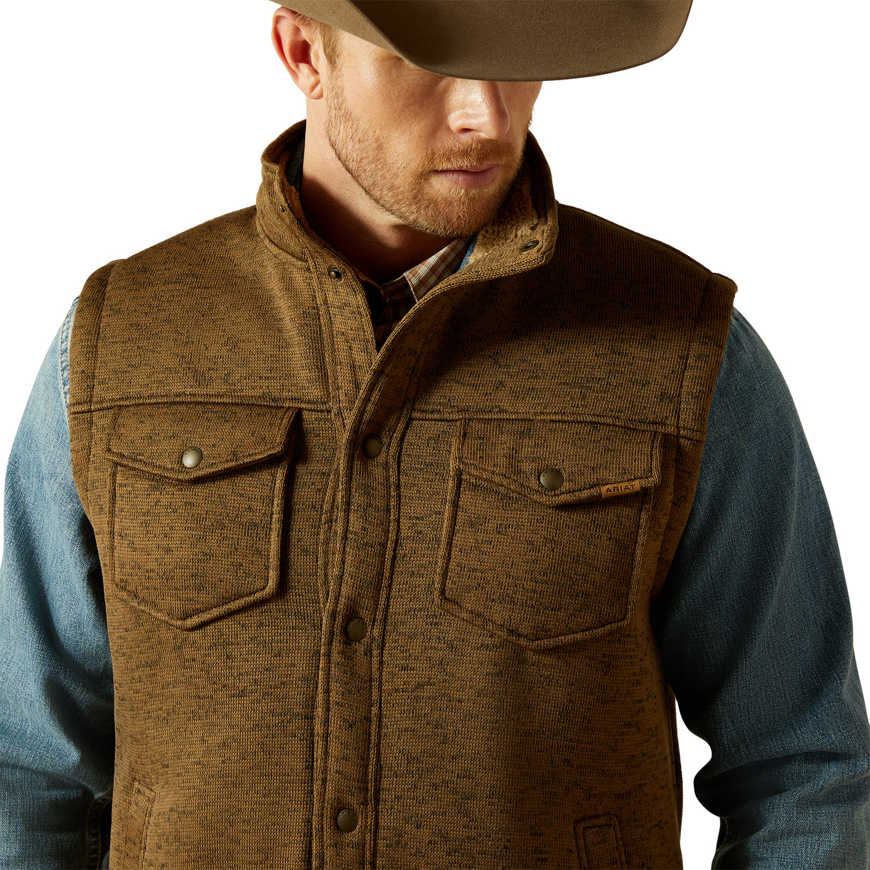 Man wearing a brown vest over a blue shirt with a white background
