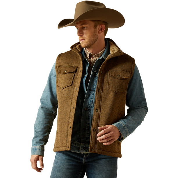 Man wearing a brown vest, blue shirt, and cowboy hat on a white background