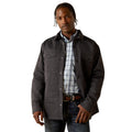 Man wearing a dark jacket over a plaid shirt on a white background