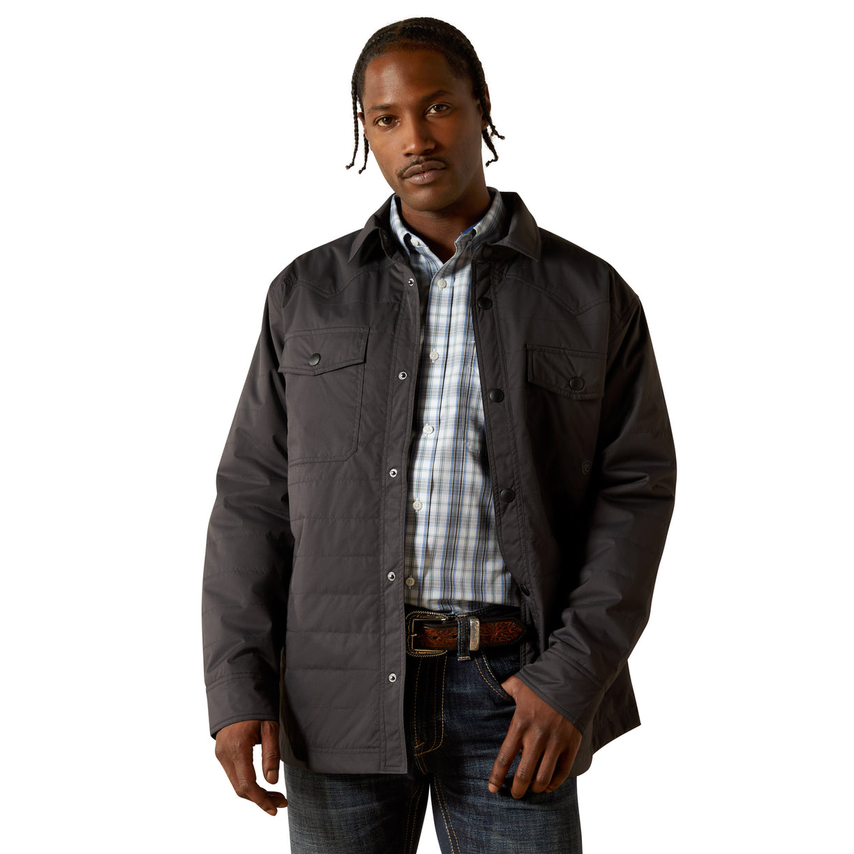 Man wearing a dark jacket over a plaid shirt on a white background