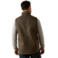 Man wearing a brown vest over a light gray shirt on a white background