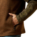 Brown jacket with a hand in the pocket and 'ARMA' branding on sleeve, on a white background