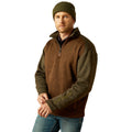 Man wearing a brown and green fleece pullover with a beanie on a white background
