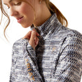 Close-up of a woman wearing a patterned jacket with a visible brand logo.