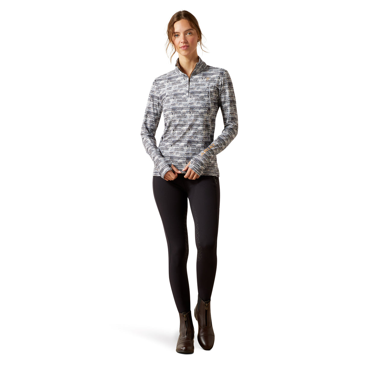 Woman wearing a patterned long-sleeve shirt and black leggings on a white background