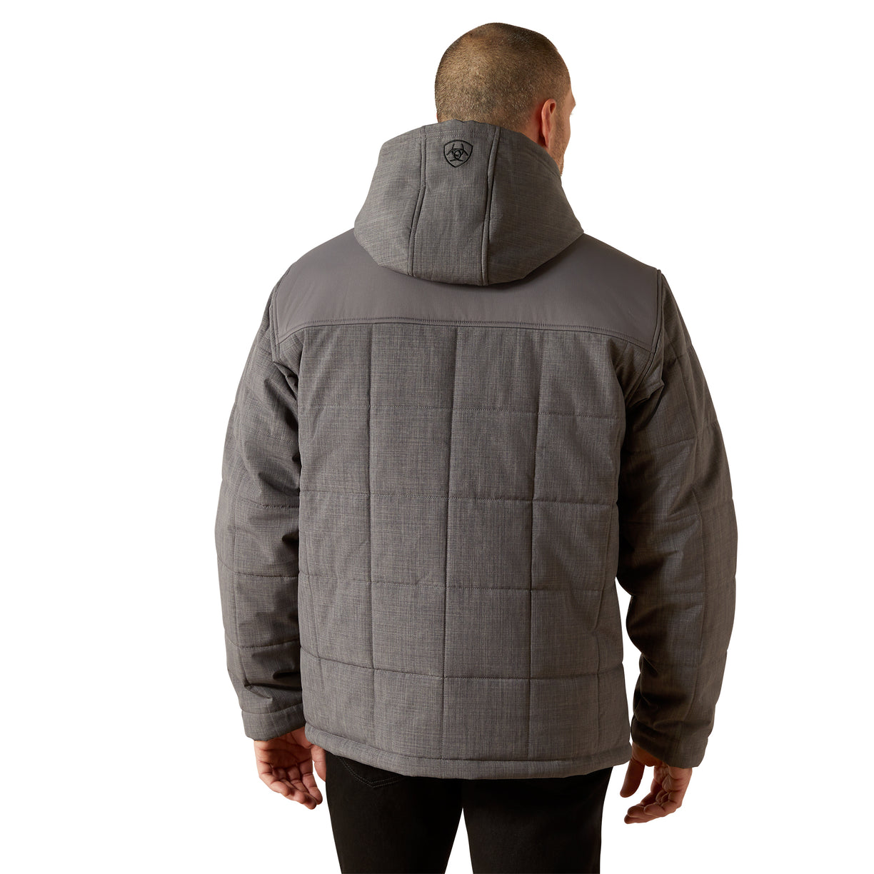 Person wearing a gray quilted jacket on a white background