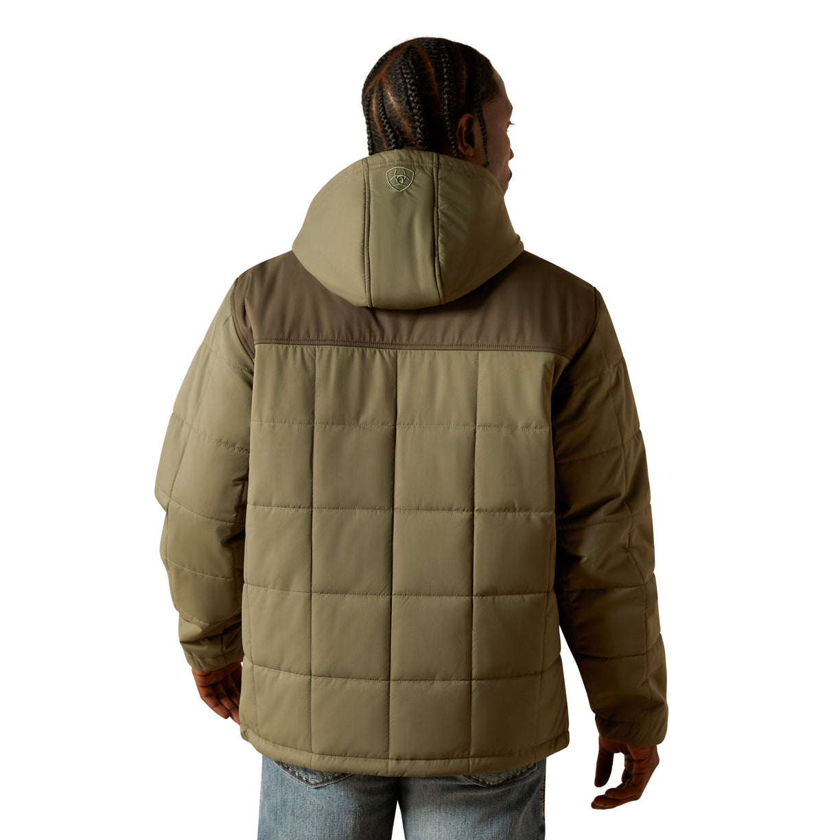 Person wearing a brown quilted jacket on a white background