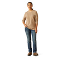 Person wearing a beige long-sleeve shirt and blue jeans on a white background