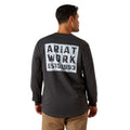 Man wearing a black long-sleeve shirt with 'Ariat Work Est. 1993' text on the back, standing against a white background.