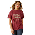 Woman wearing a maroon t-shirt with 'Ariat Denim Supply Goods' text on a white background