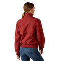 Person wearing a red jacket and blue jeans on a white background