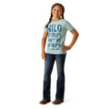Young girl wearing a light blue t-shirt with text and dark jeans on a white background
