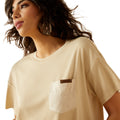 Woman wearing a beige t-shirt with a brand logo on a white background