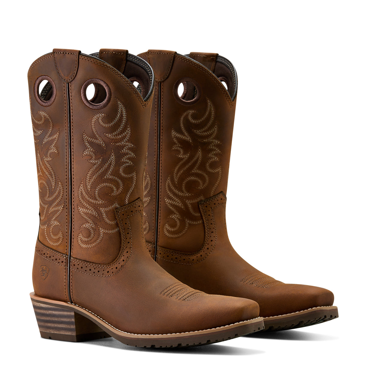 Pair of brown cowboy boots with intricate designs on a white background