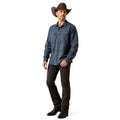 Man wearing a blue plaid shirt, black pants, and a cowboy hat on a white background