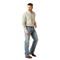 Man wearing a light-colored shirt and jeans on a white background
