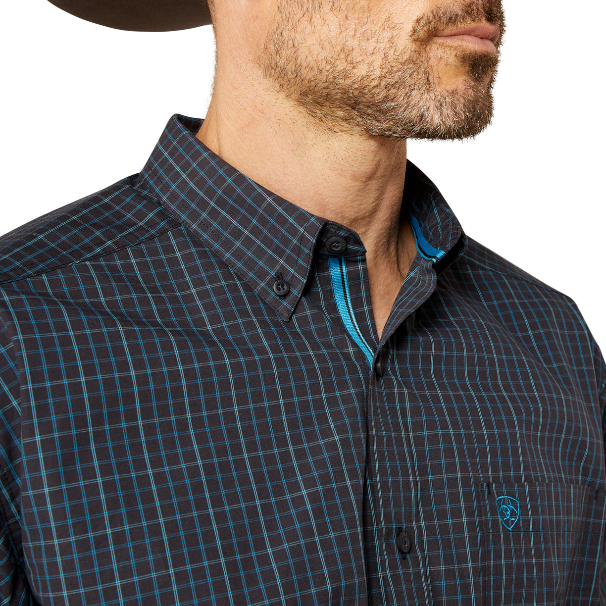 Man wearing a dark plaid shirt with a visible brand logo on a white background