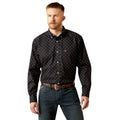 Man wearing a black patterned shirt and jeans on a white background