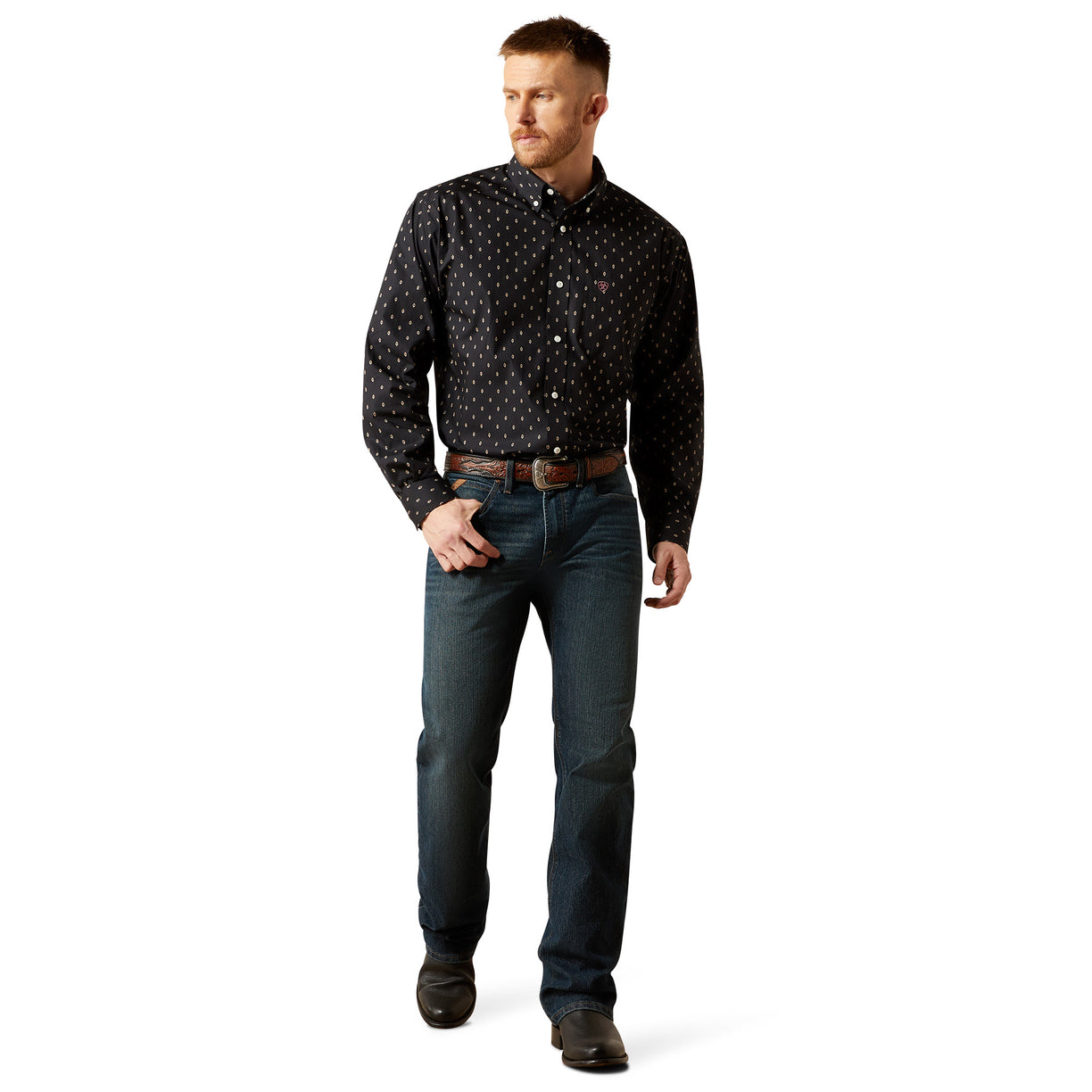 Man wearing a black patterned shirt and blue jeans on a white background