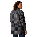Man wearing a black and white patterned shirt on a white background