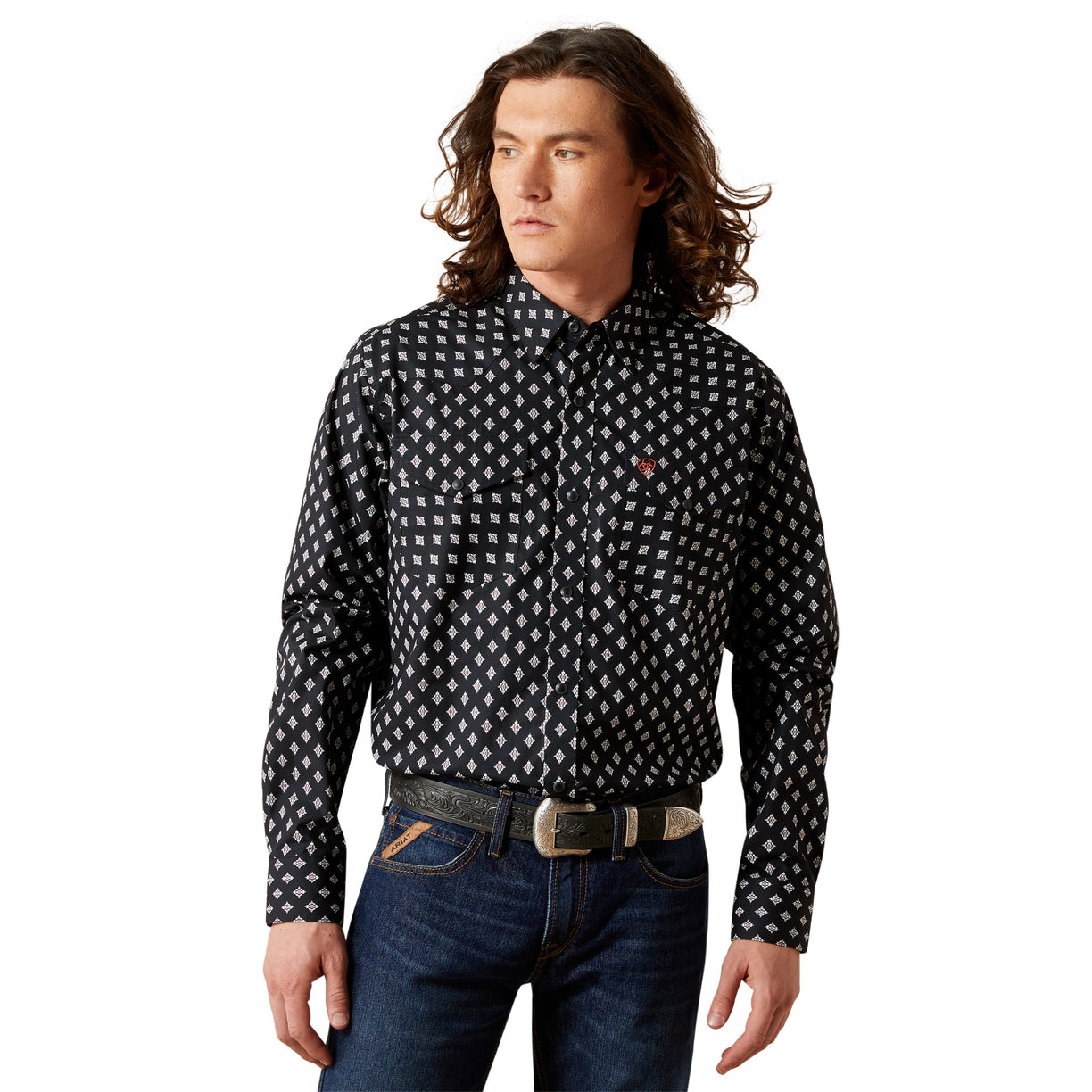 Man wearing a black patterned shirt and blue jeans on a white background