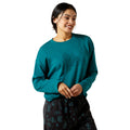 Woman wearing a teal long-sleeve shirt with a logo on a white background