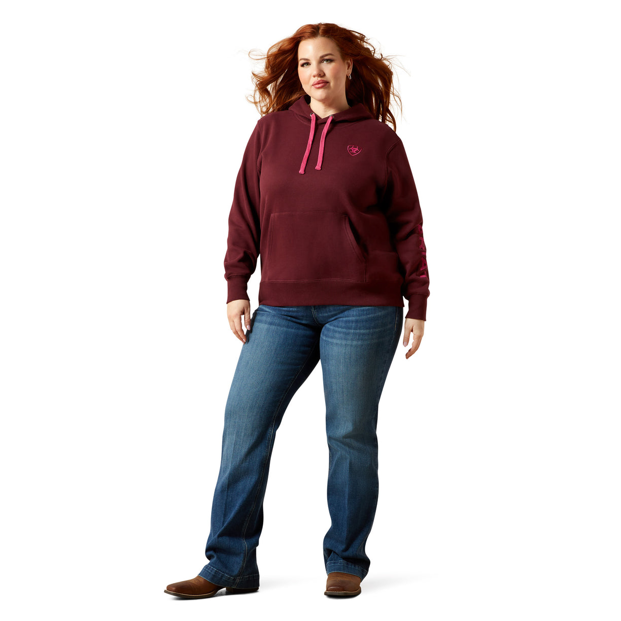 Woman wearing a maroon hoodie and blue jeans on a white background