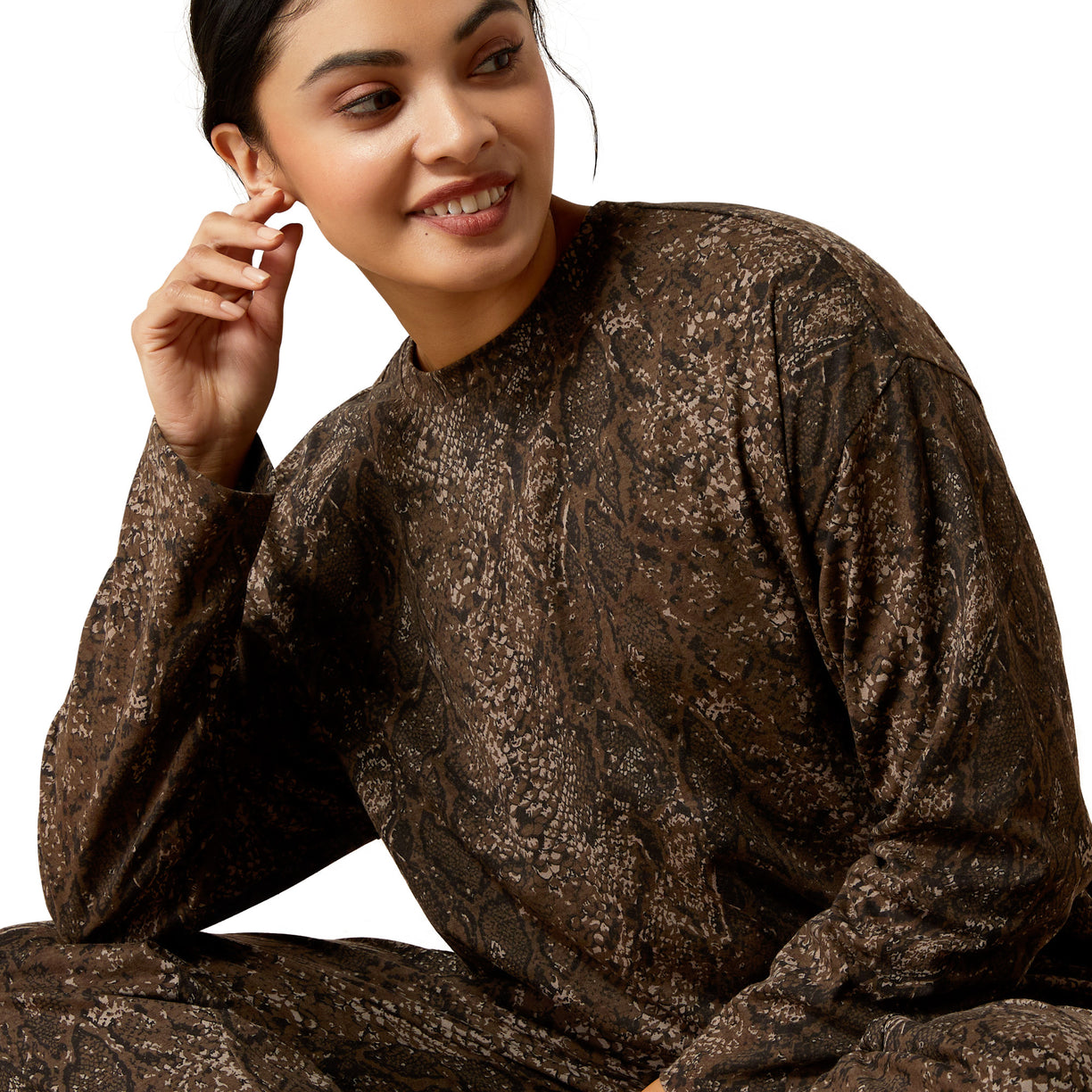 Woman wearing a brown patterned outfit on a white background