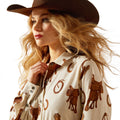 Woman wearing a cowboy hat and patterned shirt on a white background