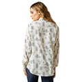 Woman wearing a long-sleeve shirt with a western pattern on a white background
