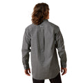 Person wearing a long-sleeve patterned shirt on a white background