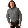 Man wearing a patterned shirt and black pants on a white background