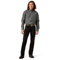Man wearing a patterned shirt and black pants on a white background