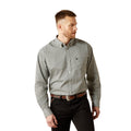 Man wearing a patterned shirt and black pants on a white background