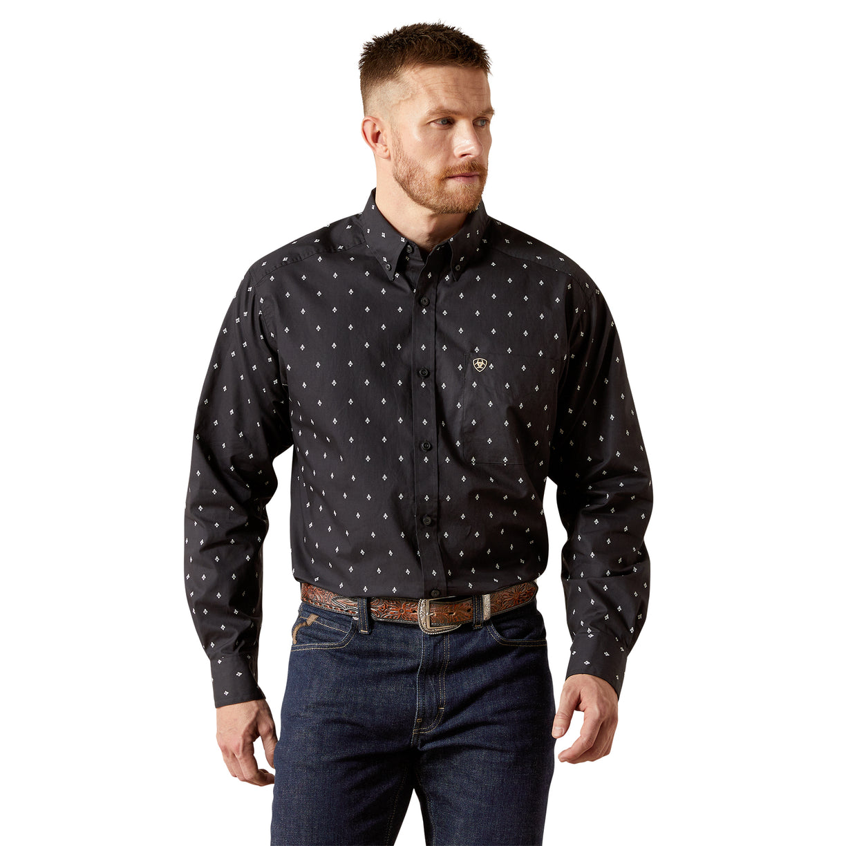 Man wearing a black patterned shirt and jeans on a white background