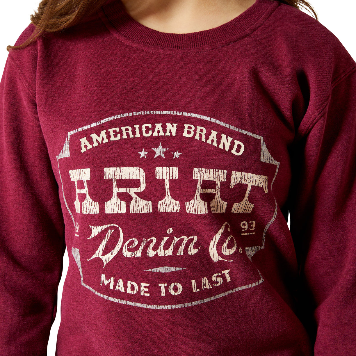 Red sweatshirt with 'American Brand Ariat Denim Co. Made to Last' text on a white background
