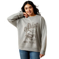 Woman wearing a gray sweatshirt with 'Ariat' branding and a scorpion graphic on a white background