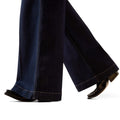 Dark blue jeans being worn on a white background