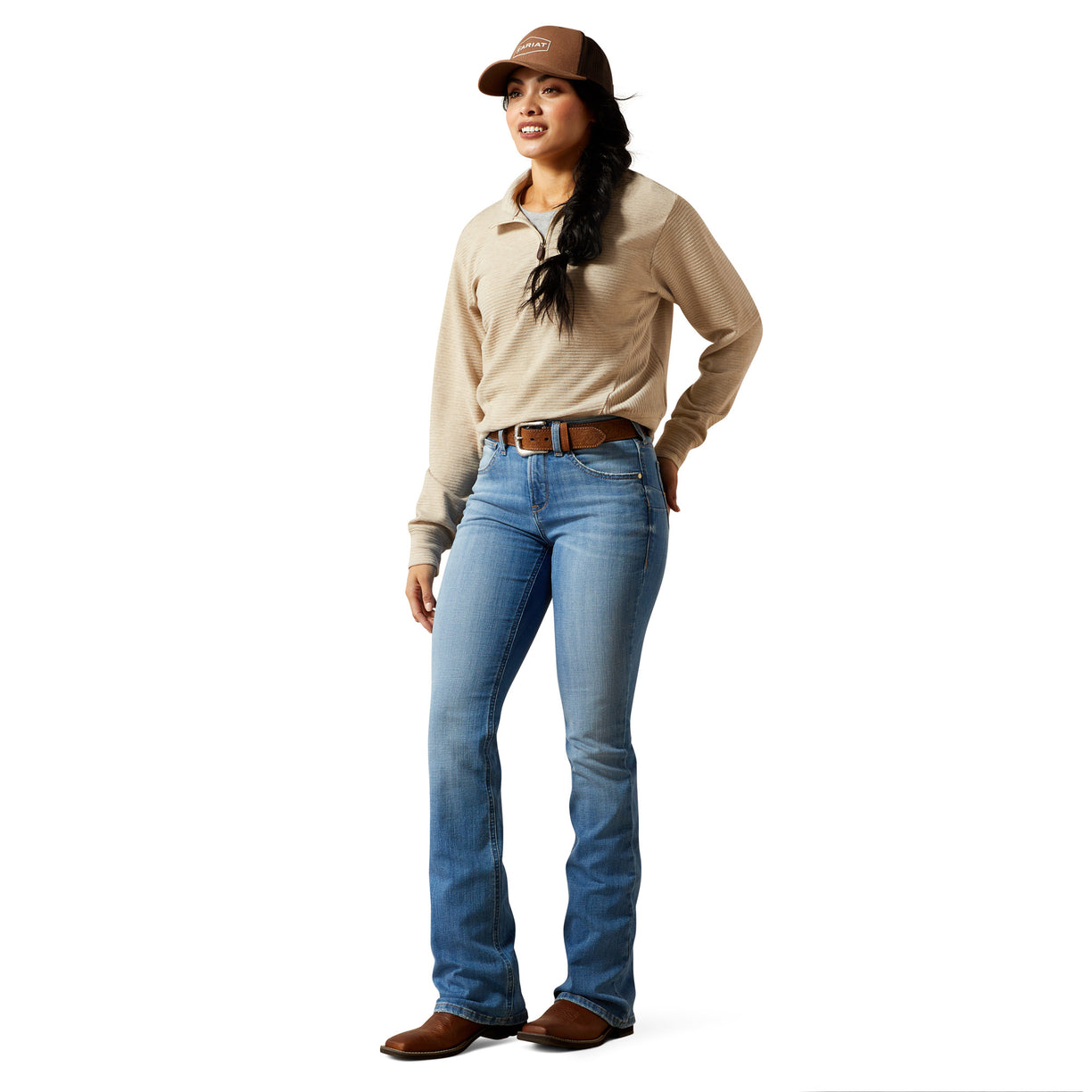 Woman wearing a beige shirt, blue jeans, and a brown cap on a white background