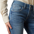 Close-up of blue jeans worn by a person on a white background
