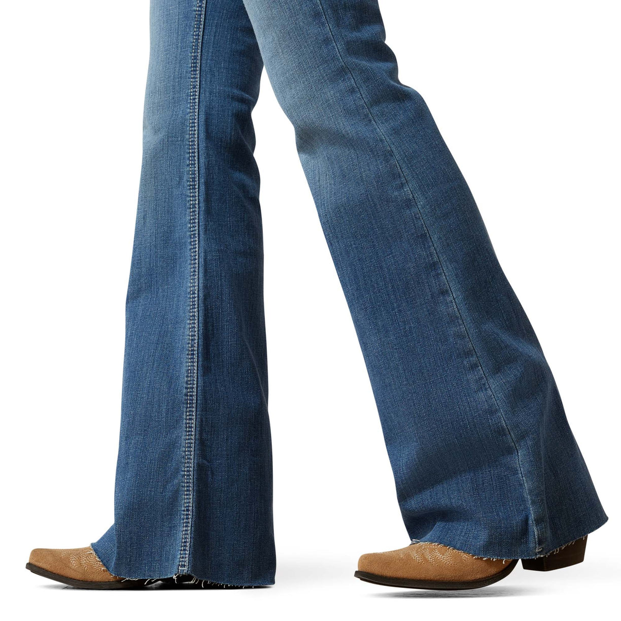 Blue jeans worn with brown shoes on a white background