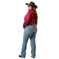Woman wearing a red shirt, blue jeans, and a cowboy hat on a white background