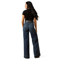 Woman wearing blue jeans and a black top on a white background