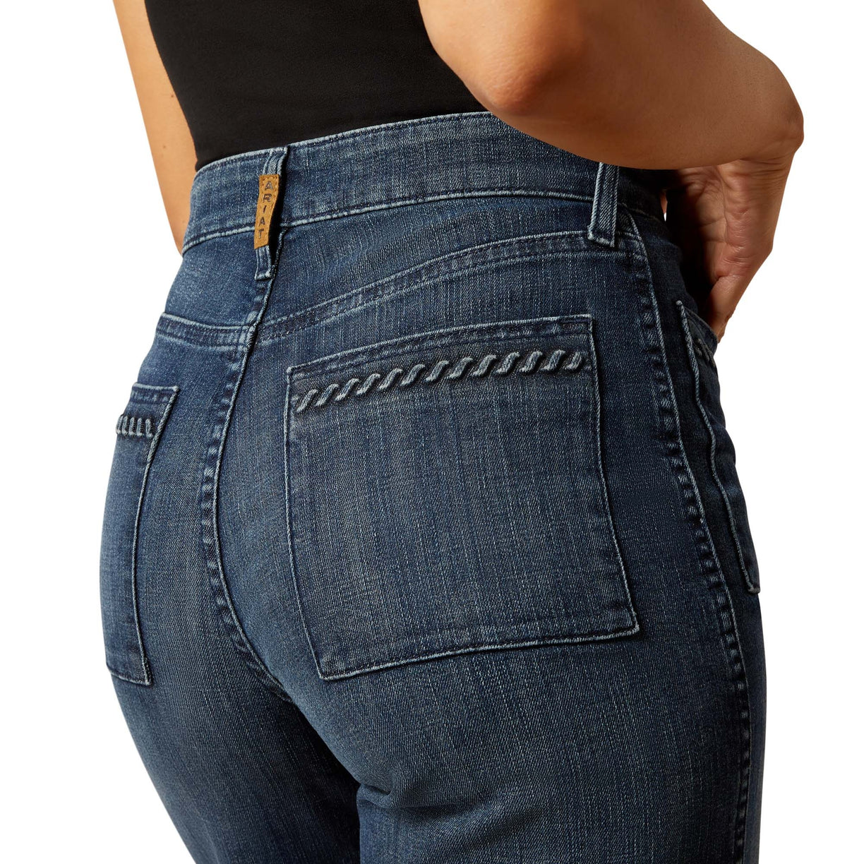 Close-up of blue jeans with decorative stitching on a white background