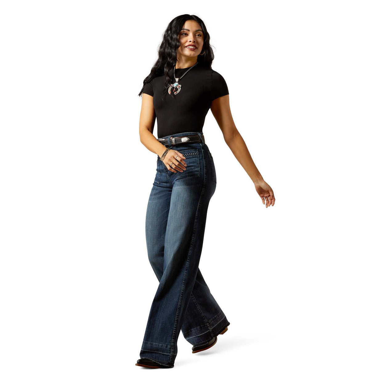 Woman wearing a black t-shirt and blue jeans on a white background
